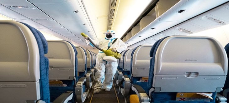 Protective-suited worker disinfecting a plane cabin—showing how COVID affected the transport industry through enhanced sanitation protocols.

